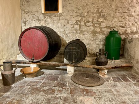 Foto de Una antigua bodega en una típica casa de campo española. Hay un gran barril de madera y algunas herramientas y utensilios para hacer vino. - Imagen libre de derechos