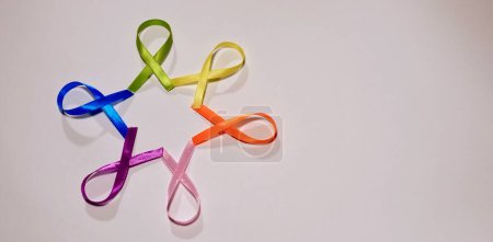 Foto de Cancer disease symbol with colored ribbons on white background close-up on world Cancer Awareness Day - Imagen libre de derechos