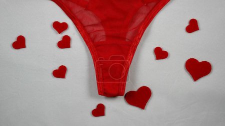 Día de San Valentín Sexy ropa interior Red Mesh Micro Bragas tanga Hold Up String. Primer plano en foco sobre fondo blanco aislado. con corazones