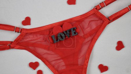 Valentines Day Sexy Underwear Red Mesh Micro Panties Thong Hold Up String. Close-up in focus on white isolated background. with hearts