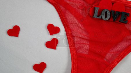 Valentines Day Sexy Underwear Red Mesh Micro Panties Thong Hold Up String. Close-up in focus on white isolated background. with hearts