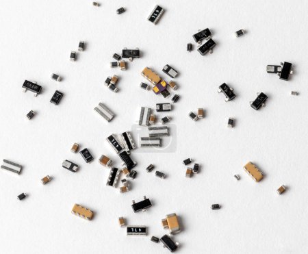 Foto de Una serie de varios componentes electrónicos y microchips dispersos aleatoriamente por una superficie blanca. - Imagen libre de derechos