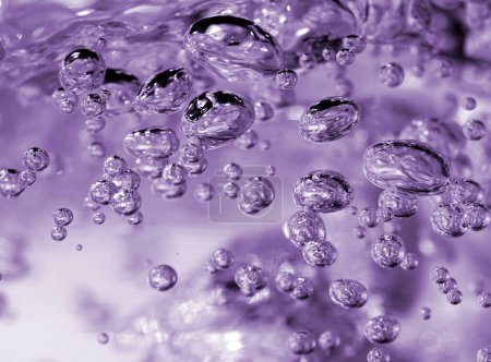Téléchargez les photos : Une photographie en gros plan de bulles d'eau effervescentes en mouvement, capturées avec une teinte violette créant un sentiment de calme. - en image libre de droit