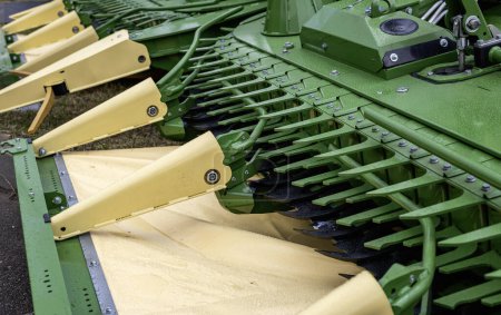 Detailliertes Bild, das die Nahaufnahme grüner und gelber Teile landwirtschaftlicher Maschinen zeigt, wobei Präzision und industrielles Design im Vordergrund stehen.