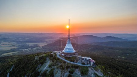 Sunset behind Jested Mountain with unique building on the summit. Liberec, Czech Republic. Aerial view from drone.