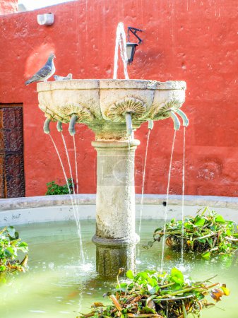 Kleiner Brunnen am Zocodover-Platz mit typisch leuchtend roter Fassade im Hintergrund. Kloster Santa Catalina, Arequipa, Peru
