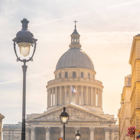 Le Panthéon de Paris baignait dans la chaleur d'un soleil couchant, avec des lampadaires et un ciel dégagé. Paris, France