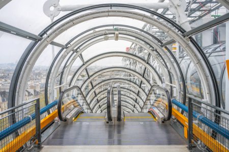 Un escalier roulant fermé traverse un tunnel transparent offrant une perspective futuriste à l'intérieur du Centre Pompidou. Paris, France