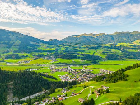 Une vue panoramique de Hollersbach im Pinzgau avec des champs verdoyants et des collines ondulantes sous un ciel clair. Hohe Tauern, Autriche