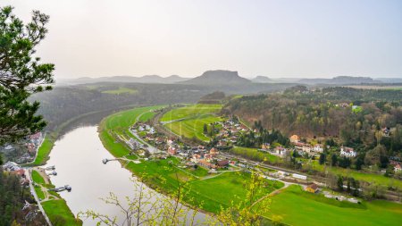 Overlooking the gentle curve of the Elbe River, surrounded by the lush greenery of Saxon Switzerland National Park. Germany
