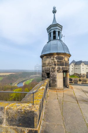 La torre de guardia de Konigstein Fortresss se alza sobre un sereno telón de fondo de colinas verdes de Sajonia y un sinuoso río. Alemania