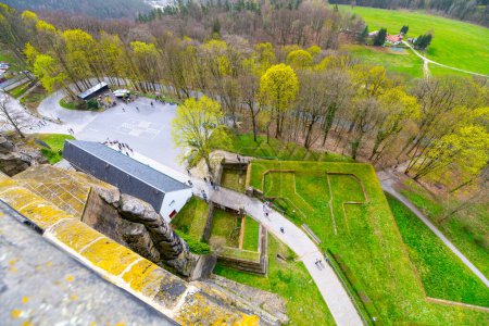 Fotografía de arriba capturando el intrincado diseño y exuberante vegetación de Konigstein Fortress con los visitantes explorando los terrenos. Sajonia, Alemania