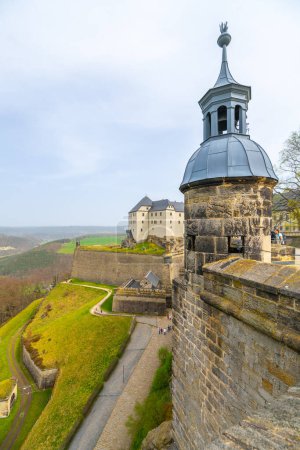 La torre de guardia de Konigstein Fortresss se alza sobre un sereno telón de fondo de colinas verdes de Sajonia y un sinuoso río. Alemania