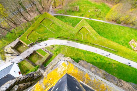 Overhead shot capturing the intricate layout and lush greenery of Konigstein Fortress with visitors exploring the grounds. Saxony, Germany