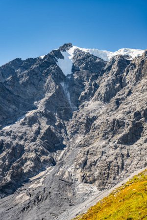 A stunning display of rugged slopes and a snow-capped summit as Ortles Mountain towers majestically under clear blue skies in the Italian Alps.
