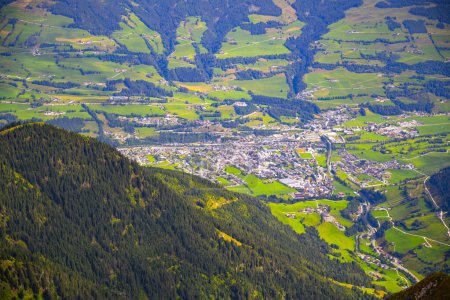 Overlooking the green landscape of Mittersill town nestled in Austrian alpine Salzach Valley, surrounded by mountains. Austrua