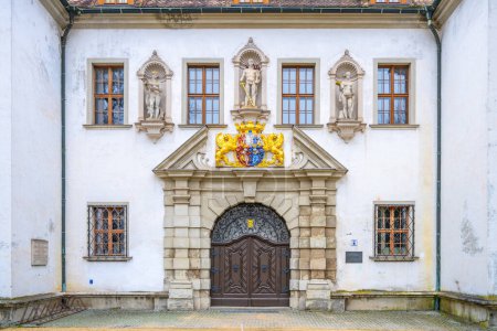 Ornate entrance door of the Old Chateau in Bad Muskau, adorned with statues and a colorful coat of arms. Saxony, Germany