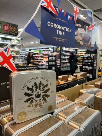Photo for Coronation Biscuits Tins displayed at shelve of supermarket MarkSpencer in London - April, 2023. Merchandise commemorating the Coronation of King Charles III. - Royalty Free Image