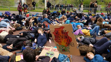 Foto de LONDRES, Reino Unido - 22 de abril de 2023. Manifestantes de la rebelión de extinción se recostaron en el pavimento durante una protesta pacífica contra el cambio climático. Día Internacional de la Madre Tierra. - Imagen libre de derechos