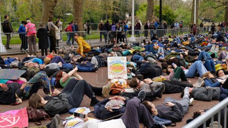 Foto de LONDRES, Reino Unido - 22 de abril de 2023. Manifestantes de la rebelión de extinción se recostaron en el pavimento durante una protesta pacífica contra el cambio climático. Día Internacional de la Madre Tierra. - Imagen libre de derechos