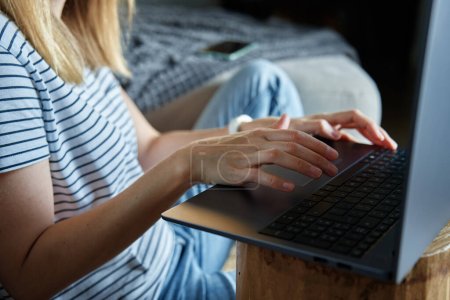 Foto de Trabajando desde el concepto casero. Mujer jands escribiendo en el teclado del ordenador portátil. Trabajo remoto desde el lugar de trabajo - Imagen libre de derechos