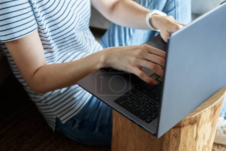 Foto de Trabajando desde el concepto casero. Mujer jands escribiendo en el teclado del ordenador portátil. Trabajo remoto desde el lugar de trabajo - Imagen libre de derechos