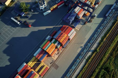 Photo for Shipping containers in terminal, Unloading containers in warehouse on railroad platform with cranes and forklifts, aerial view - Royalty Free Image