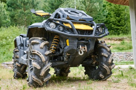 Photo for Large four-wheeler ATV vehicle is parked on green grass. Quad bike for offroad - Royalty Free Image
