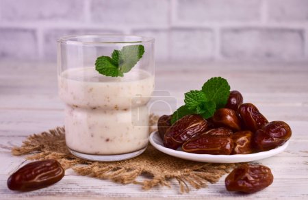 Foto de Batido de fecha con yogur en un vaso y dátiles en un plato. - Imagen libre de derechos