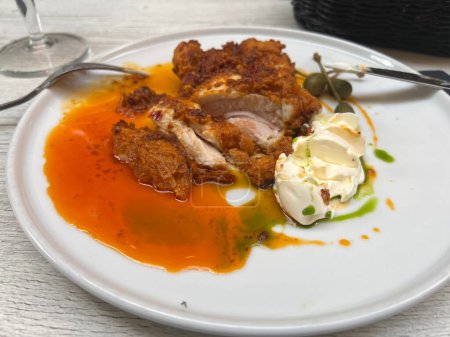 Buttermilch gebratenes Huhn und Kapern auf weißem Teller mit Honigbutter 