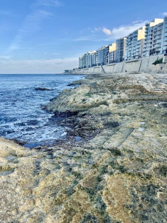 Orilla rocosa con mar azul y cielo en Sliema, Malta. Fondo natural