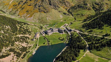 antiguo monasterio Vall De Nuria, vista del dron. Drone vuela sobre las montañas hacia el monasterio y el lago. Vista panorámica del territorio del monasterio Vall De Nuria con un hermoso lago
