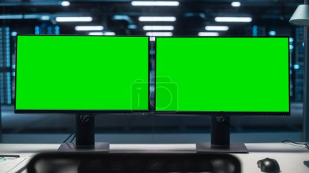 Téléchargez les photos : High-Tech Data Center Server avec deux écrans verts Chroma Key Display Affichage sur l'ordinateur personnel debout sur un bureau. Concept de surveillance moderne des services Web, Cloud Computing, cybersécurité - en image libre de droit