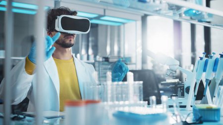 Téléchargez les photos : Laboratoire de recherche médicale futuriste : Chercheur portant un casque de réalité virtuelle, fait de la recherche sur la réalité augmentée en utilisant des gestes intelligents. Big Data AI Biotechnologie Recherche en cours - en image libre de droit