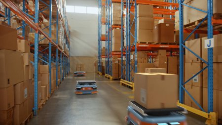 Téléchargez les photos : Future Technology 3D Concept : Automated Modern Retail Warehouse AGV Robots Transporting Cardboard Boxes in Distribution Logistics Center. Véhicules guidés automatisés livrant des marchandises, des produits et des colis - en image libre de droit