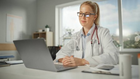 Photo for Doctor's Online Medical Consultation: Caucasian Female Physician is Making a Conference Video Call with a Patient on a Laptop Computer. Health Care Professional Giving Advice, Explaining Test Results. - Royalty Free Image