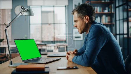 Photo for Handsome Caucasian Specialist Chatting on Video Call on Laptop with Green Screen Mock Up Display at Home Living Room. Freelance Man Chatting to Clients Over Internet on Social Networks. - Royalty Free Image