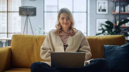 Photo for Beautiful Caucasian Specialist Working on Laptop Computer at Stylish Home Living Room while Sitting on a Cozy Couch Sofa. Freelance Female Browsing Internet, Using Social Networks, Having Fun in Flat. - Royalty Free Image
