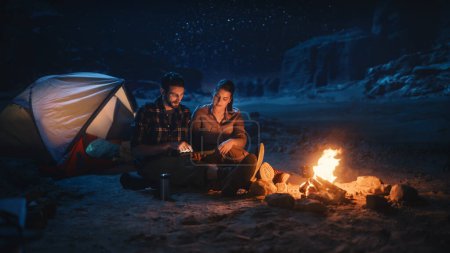 Female Traveler Sitting on Her Off Road SUV hood Watching Night Sky while Camping in the Canyon by Campfire. Traveling Woman Adventurer on Inspirational Journey Marvels at Milky Way Stars