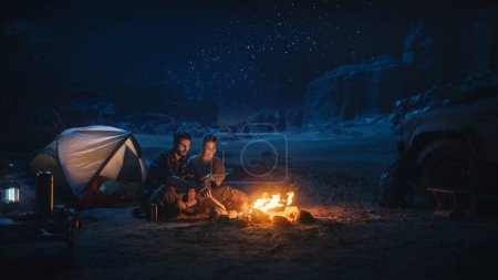 Viajera sentada en su capó todoterreno viendo el cielo nocturno mientras acampaba en el cañón junto a Campfire. Aventurera viajera en un viaje inspirador Maravillas en la Vía Láctea Estrellas
