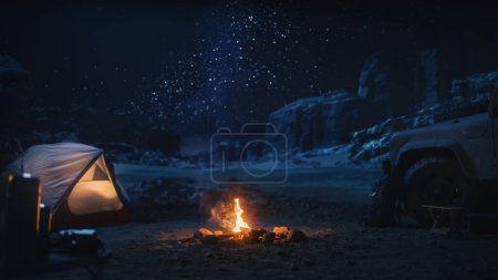 Foto de Viajera sentada en su capó todoterreno viendo el cielo nocturno mientras acampaba en el cañón junto a Campfire. Aventurera viajera en un viaje inspirador Maravillas en la Vía Láctea Estrellas - Imagen libre de derechos