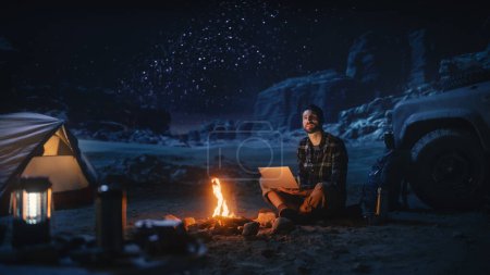 Photo for Female Traveler Sitting on Her Off Road SUV hood Watching Night Sky while Camping in the Canyon by Campfire. Traveling Woman Adventurer on Inspirational Journey Marvels at Milky Way Stars - Royalty Free Image