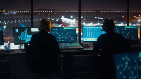Photo for Diverse Air Traffic Control Team Working in a Modern Airport Tower at Night. Office Room is Full of Desktop Computer Displays with Navigation Screens, Airplane Flight Radar Data for Controllers. - Royalty Free Image