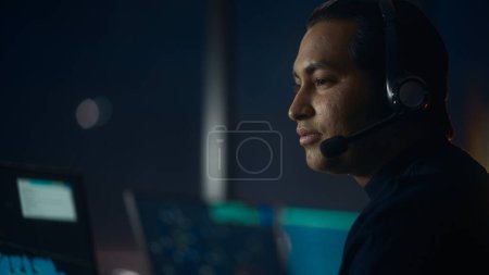 Photo for Close Up Portrait of Male Air Traffic Controller with Headset Talk on a Call in Airport Tower. Office Room is Full of Desktop Computer Displays with Navigation Screens, Airplane Flight Radar Data. - Royalty Free Image