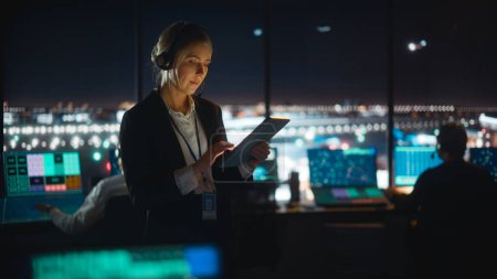 Photo for Caucasian Female Air Traffic Controller Working on Tablet in Airport Tower. Office Room is Full of Desktop Computer Displays with Navigation Screens, Airplane Flight Radar Data for the Team. - Royalty Free Image