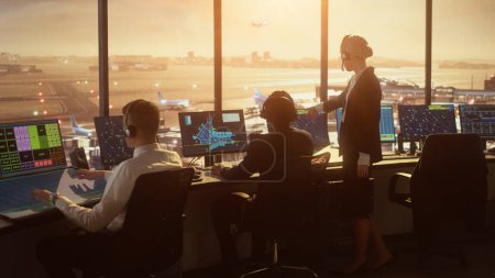 Photo for Diverse Air Traffic Control Team Working in a Modern Airport Tower at Sunset. Office Room is Full of Desktop Computer Displays with Navigation Screens, Airplane Flight Radar Data for Controllers. - Royalty Free Image