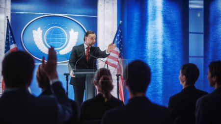 Photo for Charismatic Organization Representative Speaking at a Press Conference in Government Building. Press Officer Delivering a Speech at a Summit. Minister at Congress. Backdrop with American Flags. - Royalty Free Image