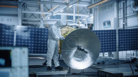 Photo for Engineer in Protective Suit Working on Satellite Construction. Aerospace Agency Manufacturing Facility: Scientists Developing Spacecraft for Space Exploration, Communications, Cosmos Observation - Royalty Free Image