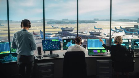 Foto de Equipo de Control de Tráfico Aéreo Diverso Trabajando en una Torre Moderna del Aeropuerto. La sala de oficina está llena de pantallas de computadora de escritorio con pantallas de navegación, datos de radar de vuelo de avión para controladores. - Imagen libre de derechos