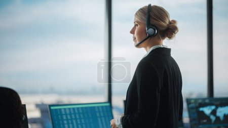 Photo for Female Air Traffic Controller with Headset Talk on a Call in Airport Tower. Office Room is Full of Desktop Computer Displays with Navigation Screens, Airplane Flight Radar Data for the Team. - Royalty Free Image
